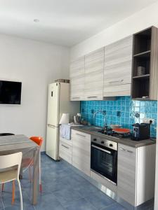 a kitchen with white cabinets and a table with a tableablish at Marechiaro House in Naples