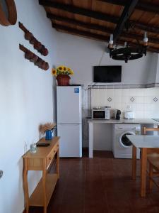 Il comprend une cuisine équipée d'un réfrigérateur blanc et d'une table. dans l'établissement Casa do Celeiro - Monsaraz, à Monsaraz
