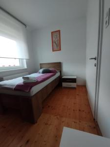 1 dormitorio con 1 cama y suelo de madera en Apartments Justin en Bled