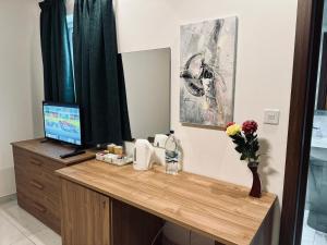 una scrivania con una televisione e un vaso di fiori di Seaside Accomodation a Marsaskala