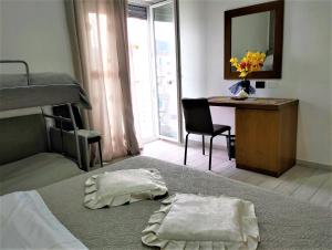 ein Schlafzimmer mit einem Etagenbett und einem Schreibtisch mit einem Spiegel in der Unterkunft Domus Michaeli B&B Pompei in Pompei