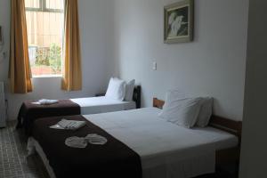 pokój hotelowy z 2 łóżkami i oknem w obiekcie Pousada Max Pomerode w mieście Pomerode
