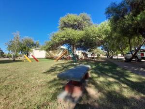 um parque infantil com um banco num parque em Valentino Apart II em Jesús María