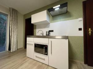 a kitchen with white cabinets and a microwave at Auf der Alm 21 N.5 in Baden-Baden