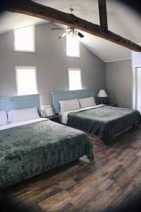 1 dormitorio con 2 camas y 2 ventanas en The Farmhouse, en Coloma