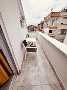 una mesa blanca y una silla en el balcón en ALPER BEY HOMES, en Antalya