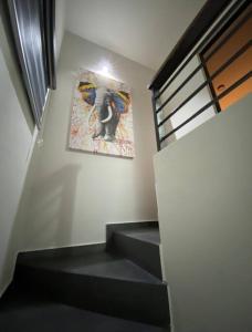 una escalera con una pintura de un elefante en la pared en Beautiful new house with pool club, en Los Bledales