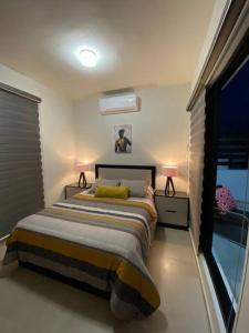 sypialnia z łóżkiem z 2 lampami i oknem w obiekcie Beautiful new house with pool club w mieście Los Bledales
