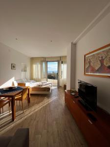 a large living room with a bed and a television at Casetta Limonella in Taormina