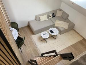 uma vista superior de uma sala de estar com um sofá e mesas em Cocon Pontissalien em Pontarlier
