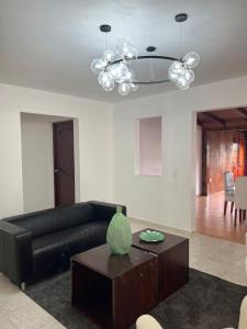 a living room with a black leather couch and a table at El Montserrat - Hotel Boutique in Santiago de los Caballeros