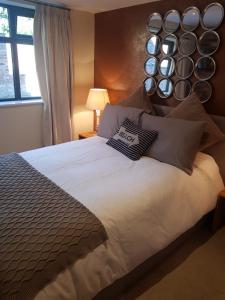 a bedroom with a large bed with plates on the wall at The Mews in Alderley Edge