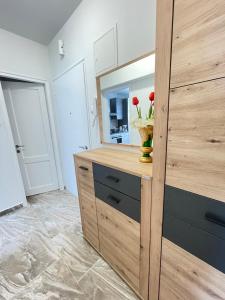 a bathroom with a wooden cabinet with a vase with flowers on it at Apartment Marina in Opatija