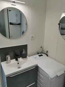 bagno con lavandino bianco e specchio di VITTEL LOC'S - LE 214, classé 3 étoiles OSEZ L'EXPERIENCE a Vittel