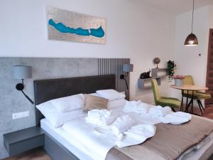 a bed with towels on it in a room at Spa Residence Carbona Silver Deluxe Apartment in Hévíz