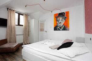 1 dormitorio con 1 cama con una pintura en la pared en Caraiman Hive en Buşteni