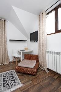 a living room with a chair and a table and a television at Caraiman Hive in Buşteni