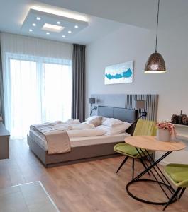 a bedroom with a bed and a table and chairs at Spa Residence Carbona Silver Deluxe Apartment in Hévíz