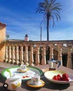 un tavolo con piatti, tazze e fragole su un balcone di Casa Susanna Rural Sardinia a Sini