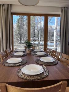 een eettafel met stoelen en een groot raam bij Chalet Deer Trail Tatranská Lomnica in Tatranská Lomnica