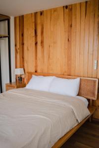 een slaapkamer met een groot bed en een houten muur bij Mya Lakeview Villa in Tang Jran Dring