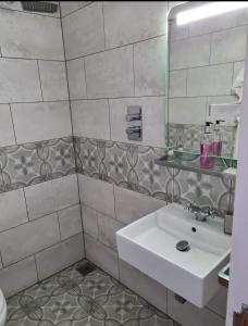 a bathroom with a white sink and a mirror at Lenox Bed and Breakfast in Hale