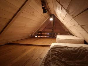 um quarto no sótão com uma cama e piso em madeira em La cabane de CHEMMALY em Flavin