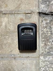 uma caixa preta no lado de uma parede de pedra em La Llamera em Ortiguero