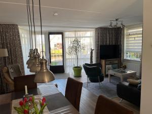 a living room with a dining table and a television at Perle am Ijsselmeer mit eigenem Tretboot in Medemblik