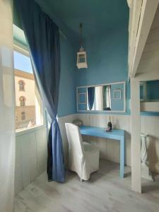 um quarto azul com uma secretária azul e uma janela em Lecco Lake em Lecco