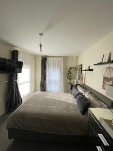 a bedroom with a large bed and a window at Central Mews House Altrincham in Altrincham