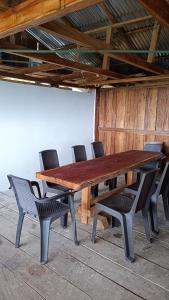 Finca El Encanto del Guejar في Lejanías: طاولة وكراسي خشبية وطاولة وكراسي