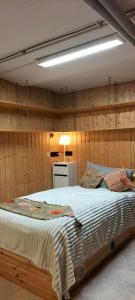 1 dormitorio con 1 cama en una pared de madera en 1 oder 2 Monteurzimmer nahe Flughafen, en Rüsselsheim