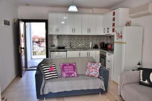 een woonkamer met een bank en een keuken bij Hisarönü Love Vacation Apartment in Fethiye