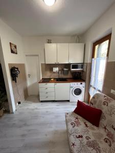 a kitchen with white cabinets and a couch in a room at Casa Vacanza Paradise 2 in Marina di Campo +11 photos