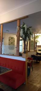 salon z czerwoną kanapą i wazą z kwiatami w obiekcie Royal Sportsman Hotel w mieście Porthmadog