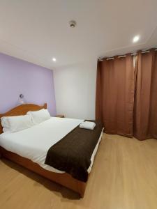 1 dormitorio con 1 cama blanca grande con manta negra en Residencial Condado, en Faro