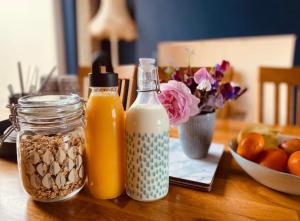 una mesa con dos botellas de zumo de naranja y un bol de fruta en Loughview en Bangor