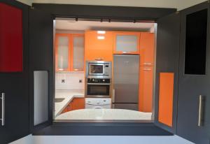 a kitchen with orange and white cabinets and a window at Ático La Real in Nájera