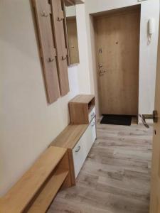 een badkamer met een wastafel en een houten deur bij Cozy two-room apartment in Liepāja