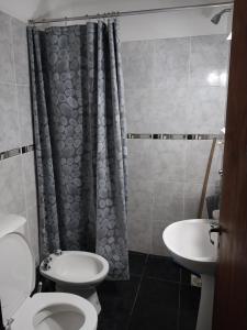 y baño con aseo, lavabo y ducha. en Dpto. 1 Lopez, de Ariel Reynoso en Mina Clavero