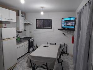 cocina con mesa y TV en la pared en Dpto. 1 Lopez, de Ariel Reynoso en Mina Clavero