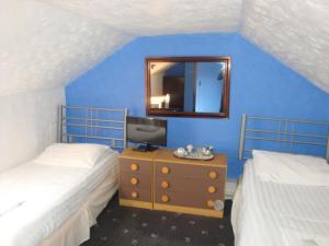 um quarto com 2 camas e uma secretária com um espelho. em Spencer Court em Ramsgate