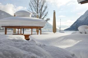 een prieel bedekt met sneeuw in een tuin bij Seehotel Einwaller - adults only in Pertisau