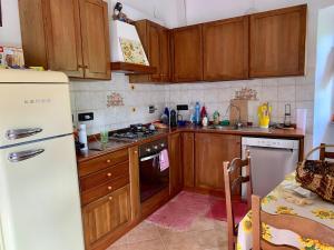 a kitchen with wooden cabinets and a white refrigerator at Amazing castle house in Mombaldone +28 photos