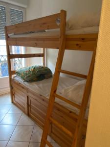 Ce lit superposé en bois se trouve dans un dortoir doté d'un oreiller. dans l'établissement Villa Garance, au Tréport