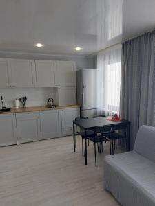 uma sala de estar com uma mesa e uma cozinha em Jelena Apartment em Rezekne
