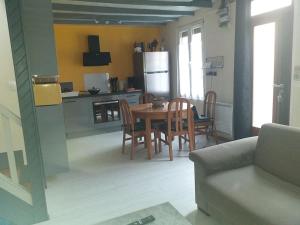 - une cuisine et une salle à manger avec une table et des chaises dans l'établissement Maison Normande avec patio, au Havre