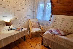 ワプシェ・ニジネにあるMiodowa Chataのベッド2台、椅子、テーブルが備わる客室です。