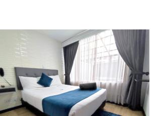 a bedroom with a bed with a large window at Hotel CGH Bogota Airport in Bogotá